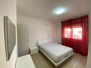 Habitación pequeña con cama y cortina roja en Amethyst Apartment, en Artena