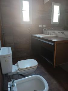 La salle de bains est pourvue de toilettes et d'un lavabo. dans l'établissement Casa de 2 plantas con parque y quincho, à Mar del Plata