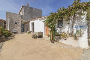 uma casa branca com plantas ao lado dela em Casa das Bonecas em Farelos de Baixo