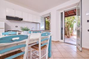 a kitchen with a table and chairs and a door at Blu - Euroappartamenti in San Vincenzo
