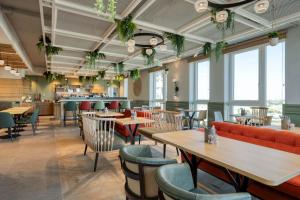 un ristorante con tavoli, sedie e finestre di Citadines Danube Vienna a Vienna