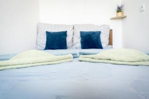 łóżko z niebieską pościelą i niebieskimi poduszkami w obiekcie Apartament Kapitan w Świnoujściu