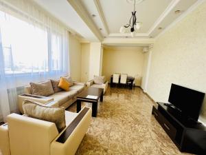 a living room with a couch and a flat screen tv at New Building Luxury and Large Apartment in Center with Balcony + Amazing View, Near Opera & Norther Avenue in Yerevan