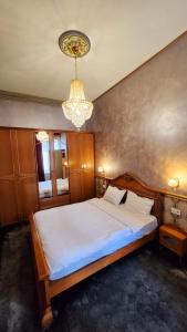 um quarto com uma cama grande e um lustre em NF Palace Old City Bucharest em Bucareste