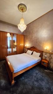 Un dormitorio con una cama grande y una lámpara de araña. en NF Palace Old City Bucharest, en Bucarest