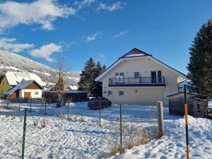 une maison blanche avec une clôture dans la neige dans l'établissement Luxury villa 2-10 people with Sauna close to Lift / FIS Ski slope, à Sankt Michael im Lungau