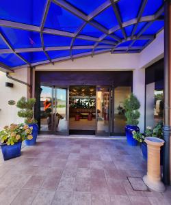 ボローニャにあるホテル インペリアルの青い天井と鉢植えの建物の入口