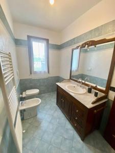 uma casa de banho com um lavatório, um WC e um espelho. em Marina Garden em Marina di Massa