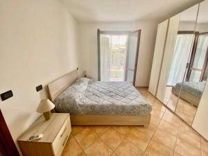 um pequeno quarto com uma cama e uma janela em Marina Garden em Marina di Massa