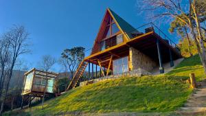 a house on top of a grassy hill at CABANA HAIGAZ de MONTANHA in Marmelopolis
