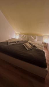 a bedroom with a large bed with black blanket at Ferienwohnungen Hexenstieg & Wurmbergblick in Schierke