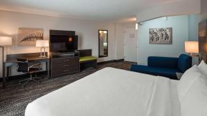Habitación de hotel con cama, escritorio y TV. en Best Western Plus Wausau Tower Inn, en Wausau