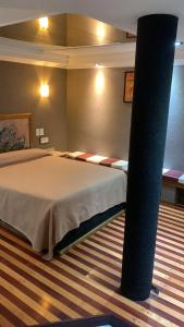 una habitación con una cama y un poste en ella en San Isidro Suite en Las Heras