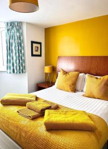 a bedroom with a large bed with yellow walls at Blue Star House in Portsmouth