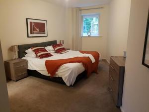 a bedroom with a bed with red pillows and a window at The Sawmills in Carlisle