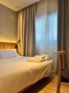 a bedroom with a bed and a window with curtains at Casa Papagayo in Cordoba