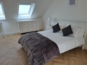 a bedroom with a large white bed with a window at 13 Cambrian Court in Penmaen-mawr +4 photos