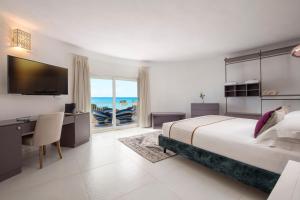 um quarto com uma cama, uma secretária e uma televisão em Villa Escargot Luxury in Costa Rei Beach em Costa Rei