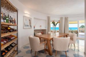 ein Esszimmer mit einem Tisch, Stühlen und Meerblick in der Unterkunft Villa Escargot Luxury in Costa Rei Beach in Costa Rei