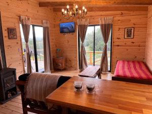 ein Esszimmer mit einem Tisch in einer Blockhütte in der Unterkunft Cabaña Los Ceibos. in Villa Serrana