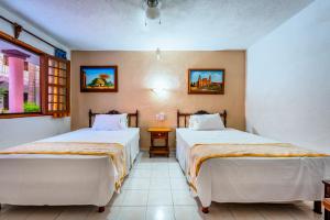 a bedroom with two beds and a window at Hotel Santa Lucía in Mérida