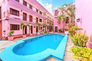 a swimming pool in front of a pink building at Hotel Santa Lucía in Mérida