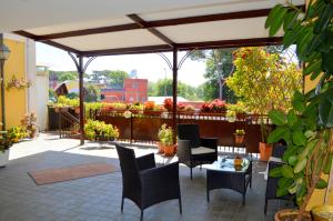 eine Terrasse mit Stühlen, einem Tisch und Blumen in der Unterkunft Hotel Shasa in Rom