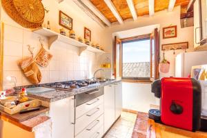 a kitchen with white cabinets and a red refrigerator at Casa vacanze Val d'orcia in Campiglia dʼOrcia