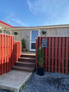 セールフォスにあるByggðarhornの門付きの家の前の赤い柵