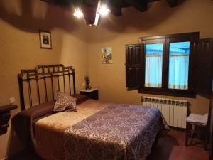 a bedroom with a bed and a window at CASA RURAL LA CASA DE LOS POLLOS in Turrubuelo