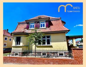 a yellow house with a red roof at Altbauvilla im Herzen von Lorsch in Lorsch