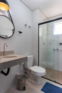 ein Bad mit einem WC und einer Glasdusche in der Unterkunft Apartamento na Praia Grande II - Pé na Areia in Praia Grande