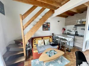 een woonkamer met een bed en een keuken bij Maisonnette de bord de mer in Guidel