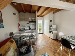 een keuken en een woonkamer met een tafel en stoelen bij Maisonnette de bord de mer in Guidel