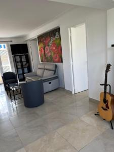 een woonkamer met een bank en een gitaar bij Au meilleur quartier de Cannes in Cannes