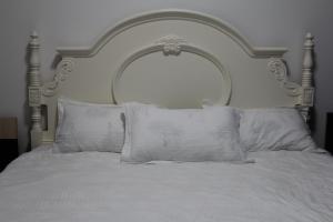 a white bed with a large headboard with white pillows at ЖК Терра in Almaty