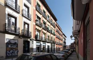 a city street with cars parked in front of buildings at Paz y calma en Madrid centro in Madrid