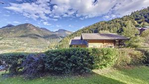 a house on a hill with mountains in the background at riam s6 in Saint-Jean-dʼAulps
