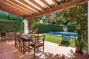 a patio with a table and chairs and a pool at Chalet en Biniancolla con piscina y jardin in Sant Lluis