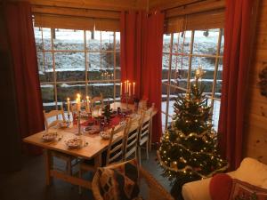 a table with a christmas tree in a room with windows at Skjerping gårdshus, in Lonevåg