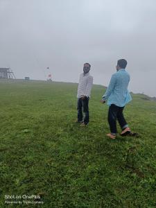two people standing in a field flying a kite at Hotel Himalayan Galaxy in Chakrāta