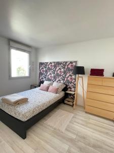 ein Schlafzimmer mit einem Bett, einer Kommode und einem Fenster in der Unterkunft Cosy appart proche Paris in Saint-Denis