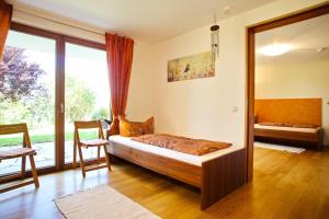 a bedroom with a bed and a large window at Freiraum in Weiler-Simmerberg