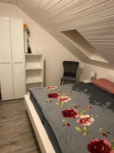 カロリーネンジールにあるCarolinensiel/Harlesielのベッドルーム1室(赤い花のベッド1台付)