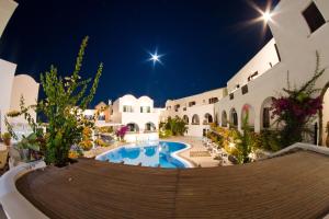 a resort with a swimming pool at night at New Haroula in Fira
