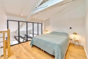 a bedroom with a bed and a large window at Appartement Croisette Cannes centre in Cannes