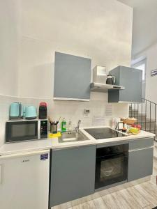 eine Küche mit einer Spüle und einer Mikrowelle in der Unterkunft Appartamento Il Tempio Della Capitale in Rom