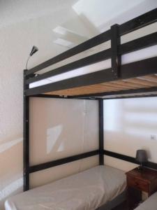 Ce lit se trouve dans un dortoir doté de 2 lits superposés et d'une lampe. dans l'établissement Azur Sancy Skis aux pieds, à Le Mont-Dore