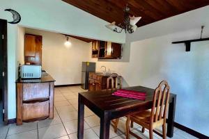 cocina y comedor con mesa de madera y sillas en Casa I’x (Jaguar), en San Juan La Laguna