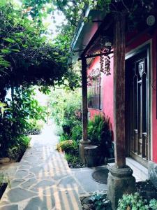 聖胡安拉拉古納的住宿－Casa I’x (Jaguar)，一条行人道,旁边是一座粉红色的房子,有一座建筑